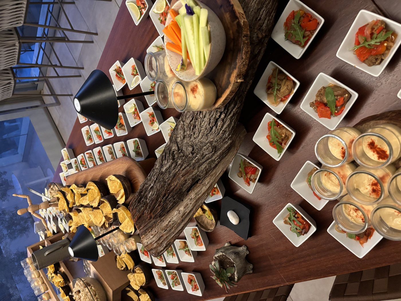 Fingerfood-Buffet mit vielen kleinen Schalen auf einem Holztisch
