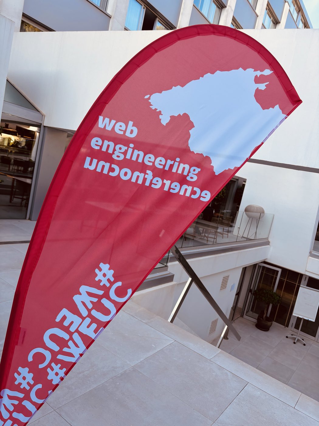 Beachflag der Web Engineering Unconference im Innenhof des Tagungshotels auf Mallorca